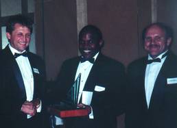 Ian Tumeil is presented with the Schneider Automation productivity improvement award by Abel Dlamini and Peter Booysen .